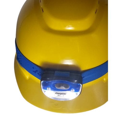 Energizer Headlamp HDA32E flood lights on while mounted on yellow hardhat using blue headband
