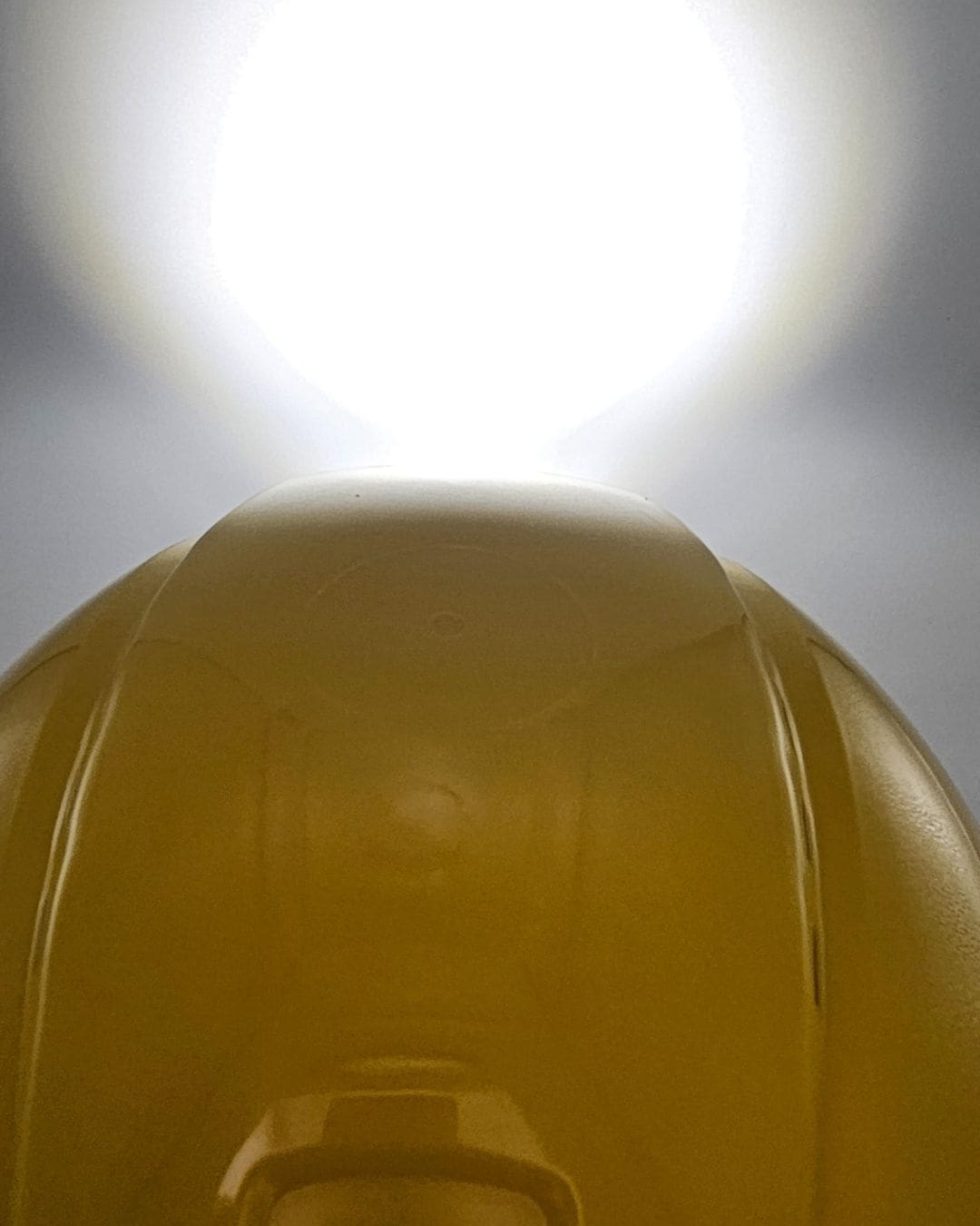 Energizer Headlamp HDBIN32EB headlamp attached to construction hardhat with white spotlight shining on wall